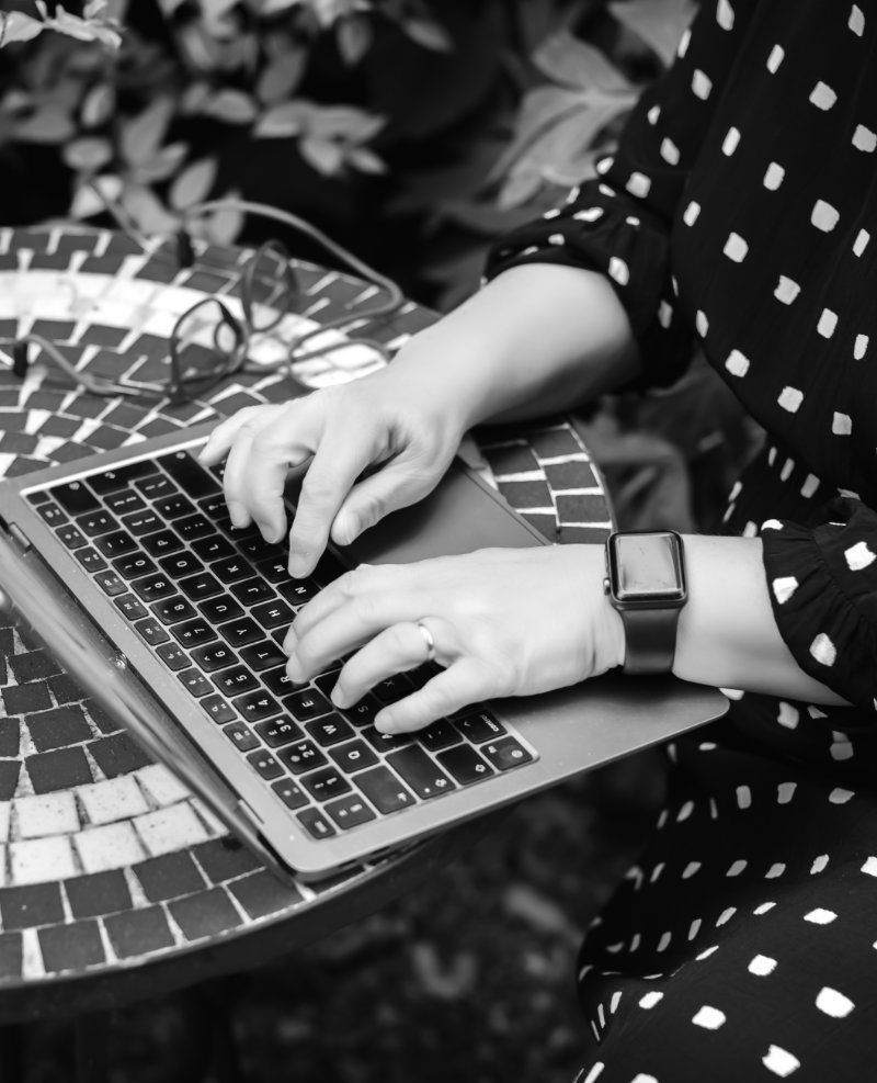 black and white image of angela typing on latop.